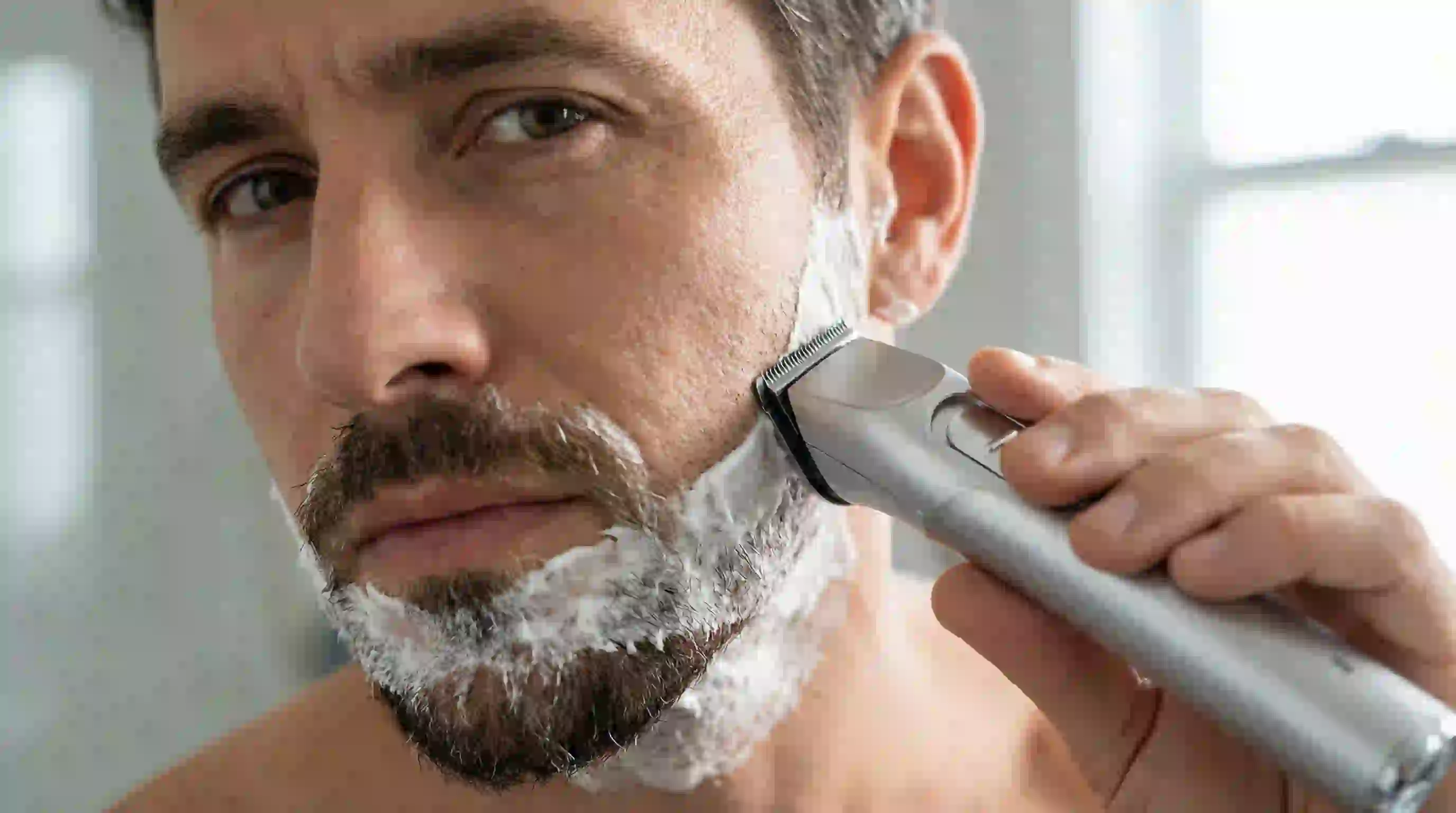 A barber performing a precise partial trim to define a goatee, offering a visual solution for how to remove patchy beard by shaping it.