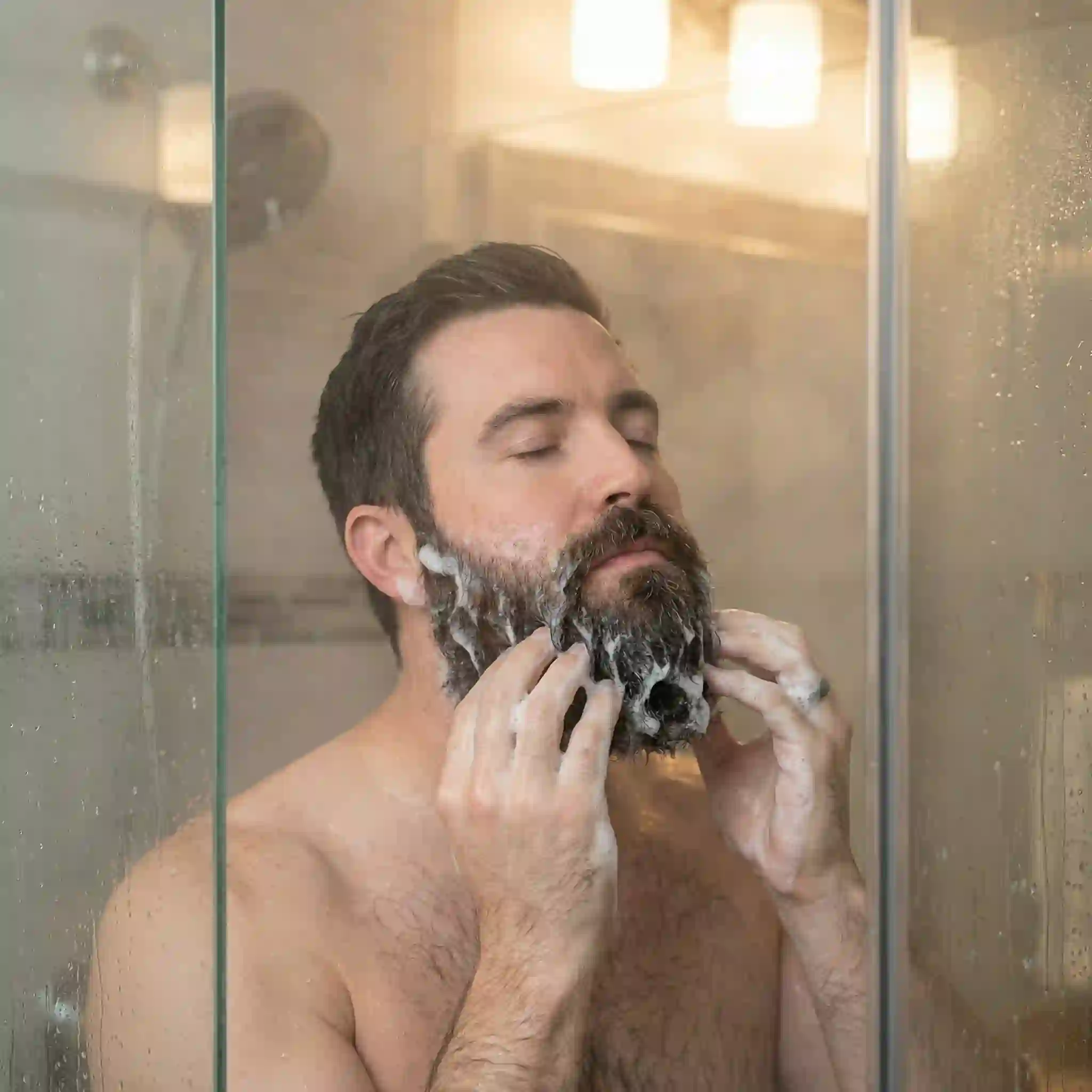 beard dandruff shampoo washing technique showing lather massaged through facial hair to reach the flaky skin underneath without scratching or irritation